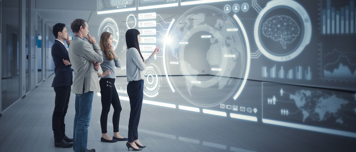Four office workers (two male, two female) in a future workspace use holographic technology during a business meeting to collaborate on a project 
