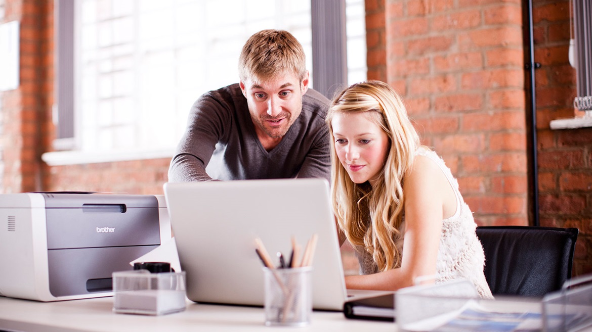 Man and lady discussing what's on their laptop screen