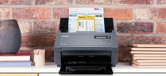 Brother PDS-6000 professional scanner scanning a document, brick wall, vase, note books