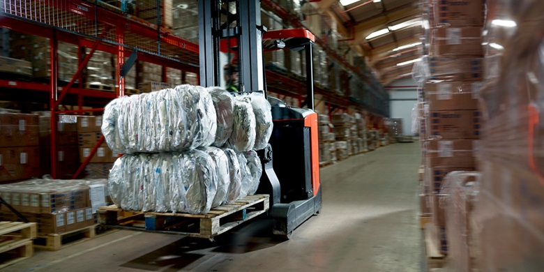 Forklift truck in a factory surrounded by boxes
