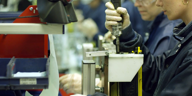 Woman and man in a factory operating a machine